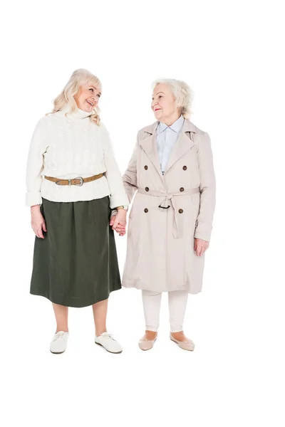 Heureux retraités femmes tenant les mains isolées sur blanc — Photo de stock