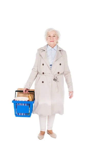 Mujer alegre sosteniendo cesta de la compra y de pie aislado en blanco - foto de stock