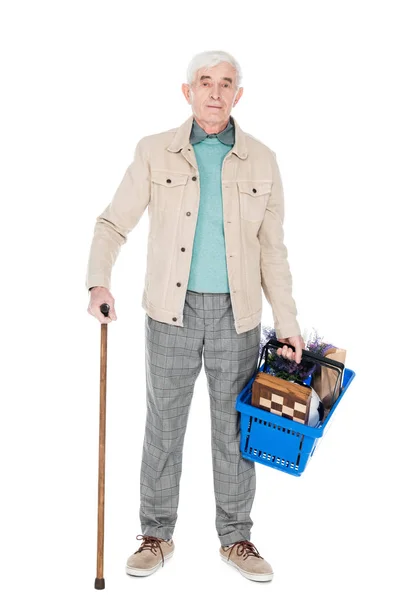 Aposentado homem segurando cana andando e cesta de compras em mãos isoladas em branco — Stock Photo
