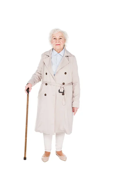 Mulher sênior alegre de pé com bengala andando isolado no branco — Fotografia de Stock