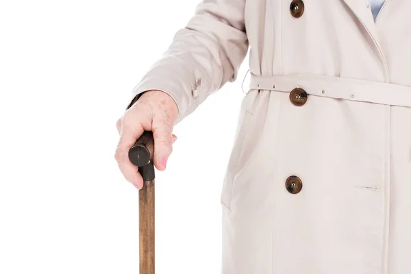 Vista recortada de la mujer mayor sosteniendo bastón aislado en blanco - foto de stock