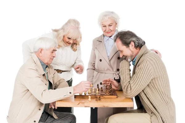 Amici in pensione giocare a scacchi vicino alle donne anziane isolato su bianco — Foto stock