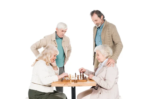 Femmes à la retraite jouant aux échecs près des hommes âgés isolés sur blanc — Photo de stock
