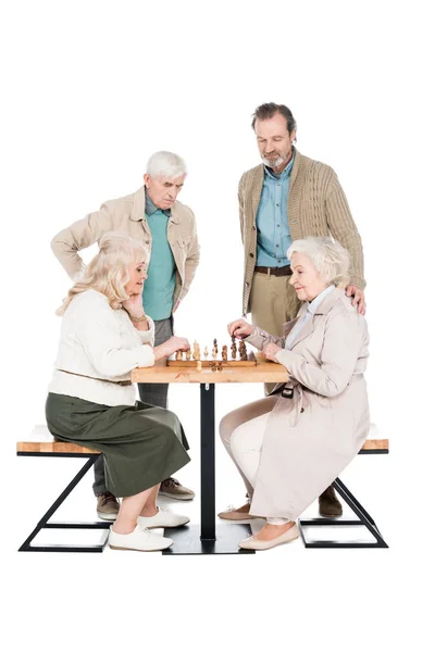 Happy senior women playing chess near retired men isolated on white — Stock Photo