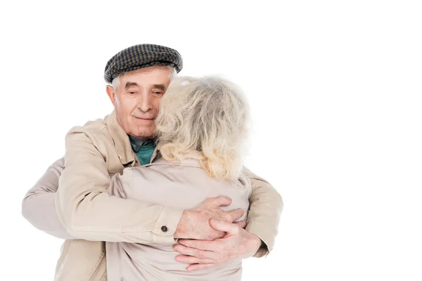 Веселый пенсионер обнимает жену, изолированную на белом — стоковое фото