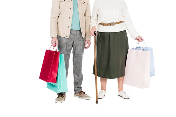 Обрізаний вид на пенсійну пару, що стоїть з сумками для покупок ізольовано на білому — стокове фото