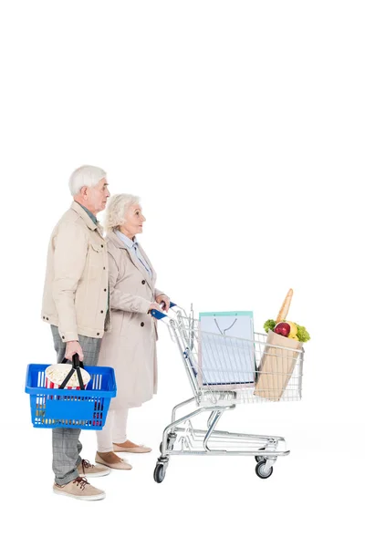 Aposentado marido e mulher andando com carrinho de compras e cesta isolada no branco — Fotografia de Stock