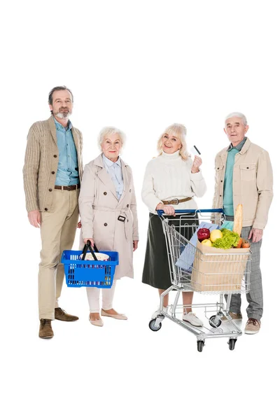 Amigos aposentados alegres de pé perto da mulher sênior com cartão de crédito isolado no branco — Fotografia de Stock