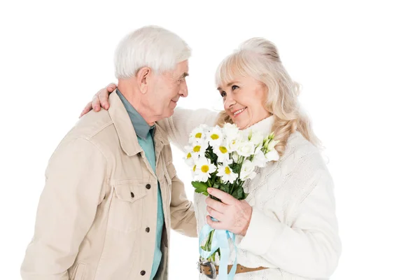 Homme âgé joyeux donnant des fleurs à femme heureuse isolé sur blanc — Photo de stock