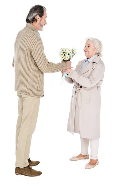 Hombre mayor dando flores a la mujer feliz aislado en blanco - foto de stock