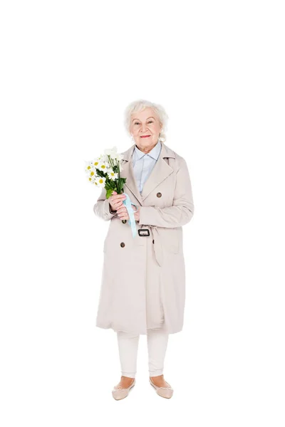 Cheerful senior woman holding flowers in hands isolated on white — Stock Photo