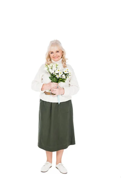 Усміхнена пенсіонерка тримає квіти в руках ізольовані на білому — стокове фото