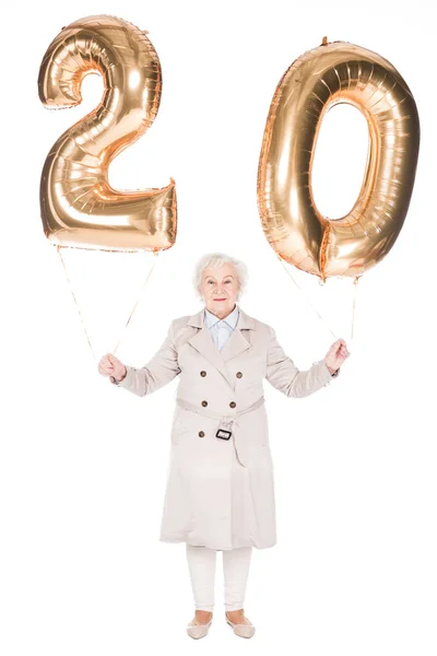 Sonriente mujer mayor sosteniendo globos aislados en blanco - foto de stock