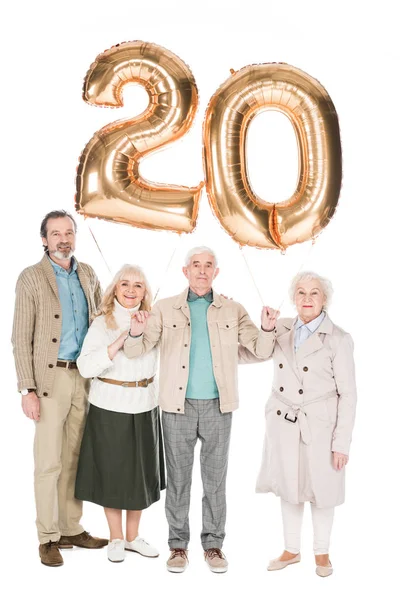 Joyeux retraités tenant des ballons isolés sur blanc — Photo de stock