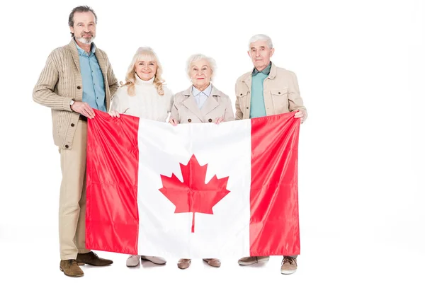 Personas mayores felices sosteniendo la bandera de Canadá aislado en blanco — Stock Photo