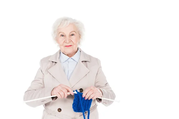 Mujer jubilada feliz de pie y tejiendo aislado en blanco - foto de stock