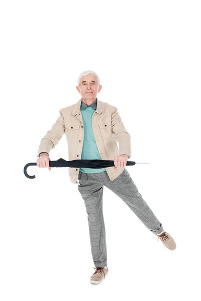 Cheerful retired man dancing with umbrella isolated on white — Stock Photo