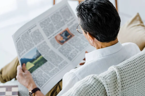 Foco seletivo do homem ler jornal em casa — Fotografia de Stock