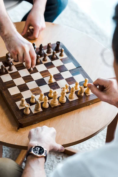 Foco seletivo de idosos jogando xadrez em casa — Fotografia de Stock