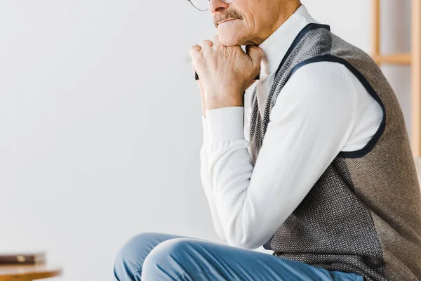 Cropped view of sad pensioner sitting at home — Stock Photo