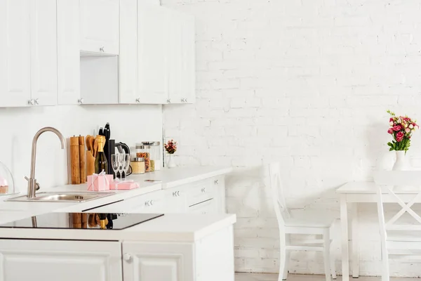 Moden interior design of kitchen with white furniture and induction cooker — Stock Photo