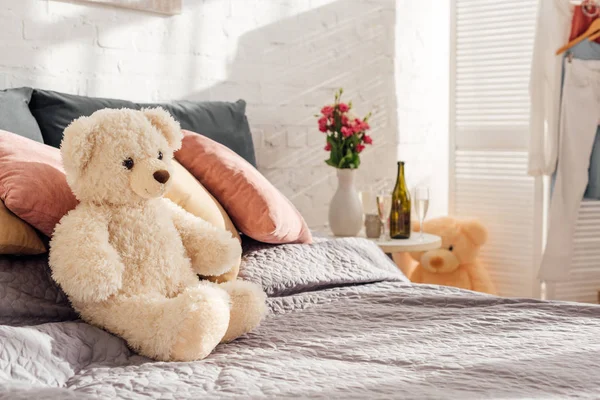 Selective focus of teddy bear toy on bed in modern bedroom with copy space — Stock Photo