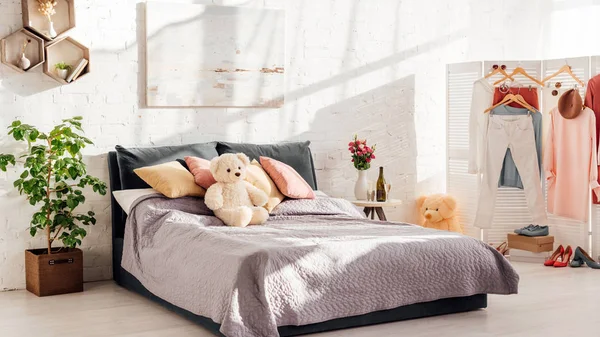 Modern interior design of bedroom with teddy bear toys, pillows, plants and bed — Stock Photo