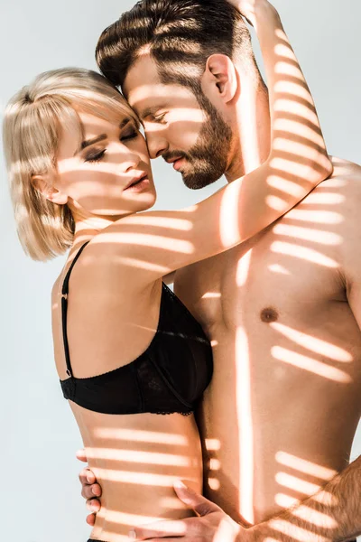 Passionate couple with closed eyes hugging isolated on grey with shadows — Stock Photo