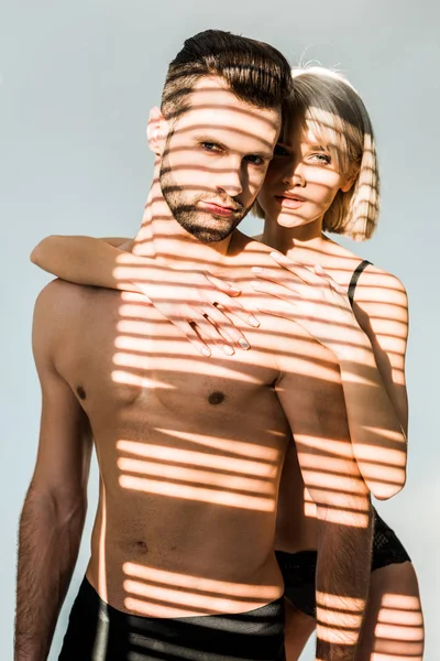 Sinnliche Frau umarmt bärtigen Mann ohne Hemd isoliert auf grau mit Schatten — Stockfoto