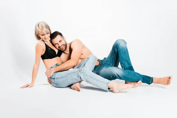Man and woman posing in underwear and jeans on grey — Stock Photo