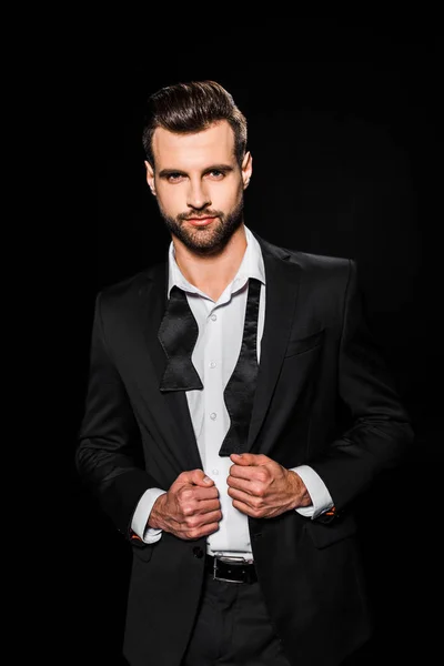 Hombre barbudo guapo en chaqueta y pajarita, aislado en negro — Stock Photo