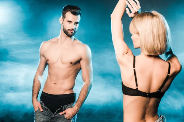 Couple sensuel en sous-vêtements posant sur fond bleu fumé — Photo de stock