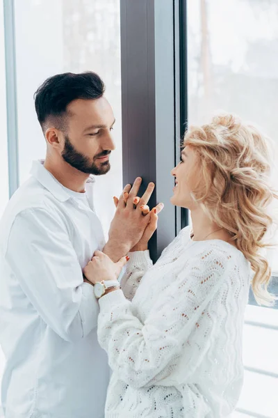 Pareja feliz tomados de la mano y mirándose - foto de stock