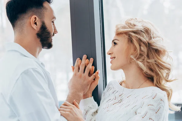 Happy couple holding hands and looking at each other with love — Stock Photo