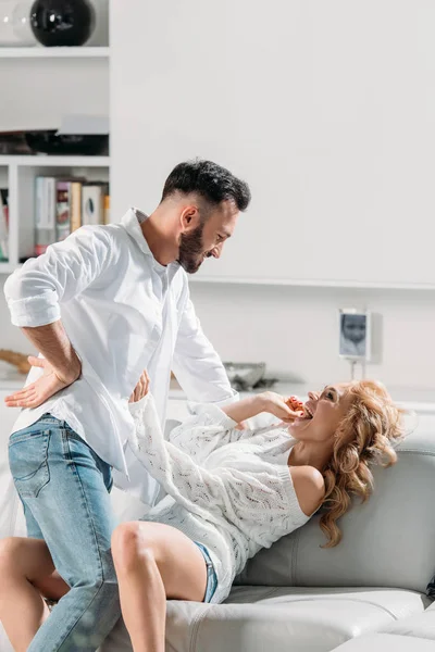 Engraçado casal rindo e se divertindo no sofá — Fotografia de Stock