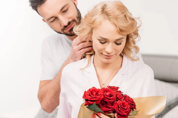 Casal romântico relaxado posando com rosas vermelhas — Fotografia de Stock