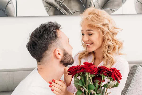 Blonde jeune femme regardant petit ami avec le sourire — Photo de stock