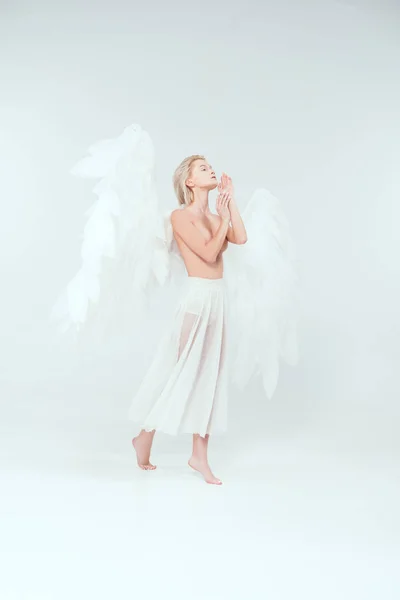 Hermosa mujer tierna con alas de ángel gesto con las manos y posando aislado en blanco - foto de stock