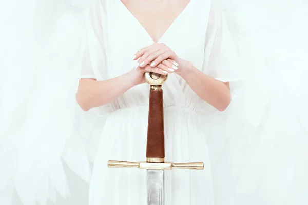 Обрізаний вид жінки з ангельськими крилами, що тримає меч ізольовано на білому — стокове фото