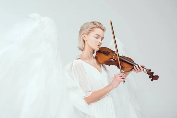 Bella donna in costume da angelo con le ali che suonano violino isolato su bianco — Foto stock