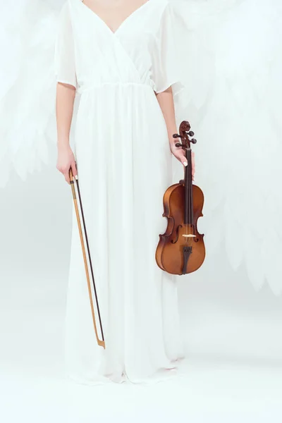 Обрізаний вид жінки в костюмі ангела з крилами, що тримають скрипку і лук ізольовані на білому — стокове фото