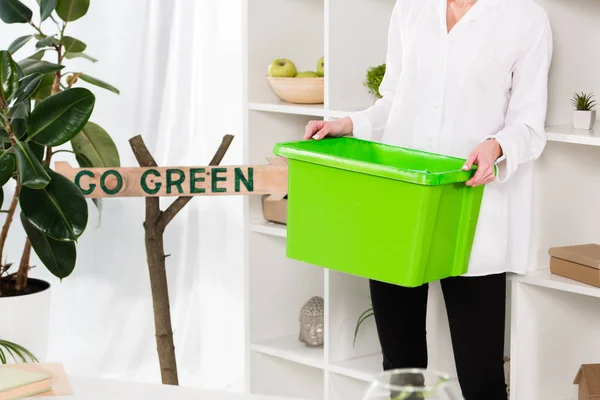 Vista cortada da mulher segurando caixa de reciclagem verde perto de ir sinal verde, conceito de poupança ambiental — Fotografia de Stock