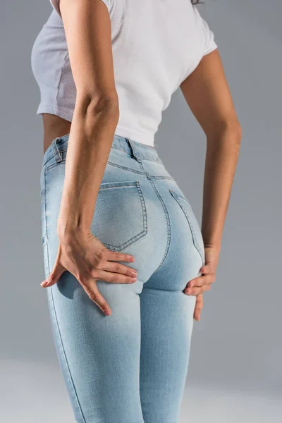 Vista cortada de menina sexy em jeans azuis no fundo cinza — Fotografia de Stock