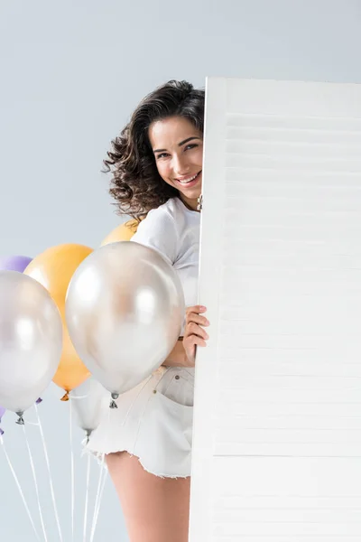 Charmante brünette Mädchen mit Luftballons auf grauem Hintergrund — Stockfoto