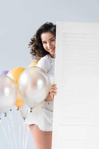 Encantadora chica morena con globos de aire sobre fondo gris - foto de stock