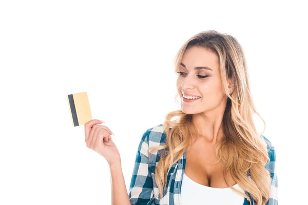 Atractiva mujer rubia en camisa azul sosteniendo tarjeta de crédito y sonriendo aislado en blanco - foto de stock