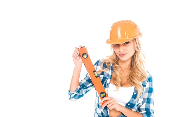 Mulher arquiteta loira em camisa azul e hardhat laranja com nível de espírito isolado no branco — Fotografia de Stock