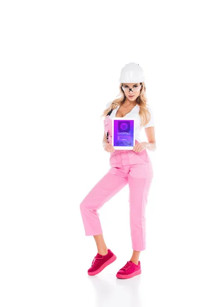 Attractive handy woman in pink uniform holding digital tablet with shopping app on screen on white background — Stock Photo