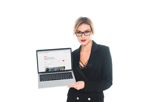 Atractiva mujer de negocios en negro formal desgaste celebración portátil con aibbnb sitio web en la pantalla aislada en blanco - foto de stock