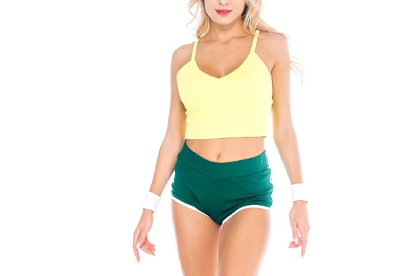 Vista recortada de la deportista en pantalones cortos verdes y soltera amarilla aislada en blanco - foto de stock